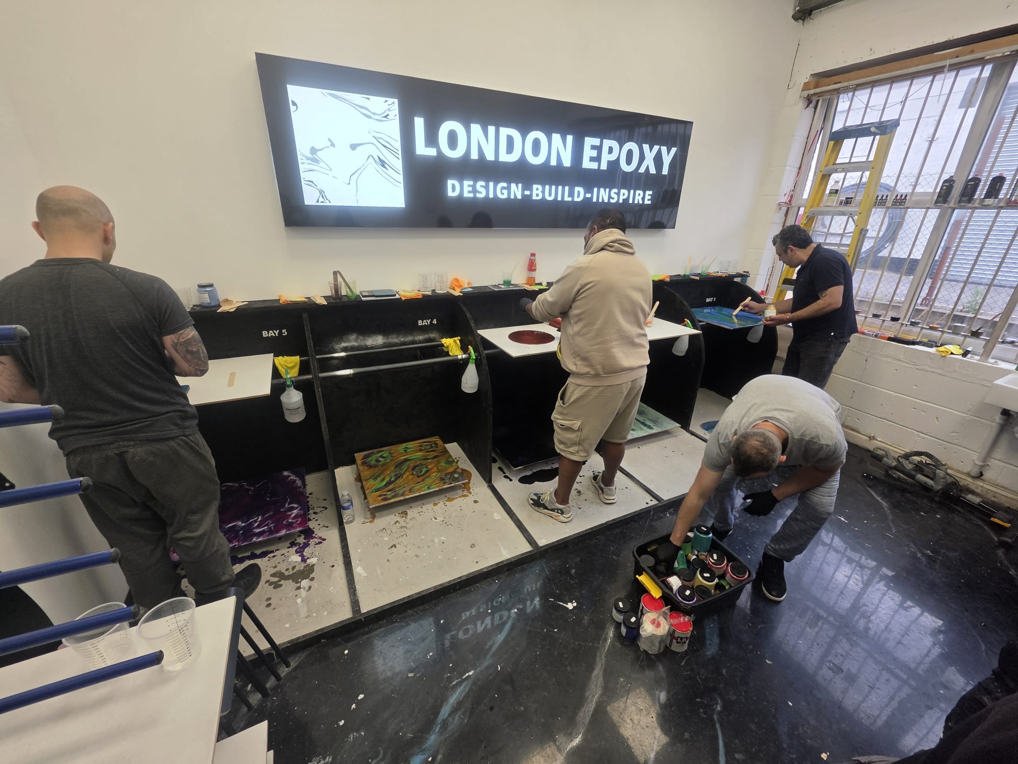 Students applying epoxy coating with squeegee during London Epoxy Academy training